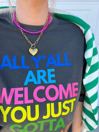 Person wearing a colorful shirt with text and a necklace.